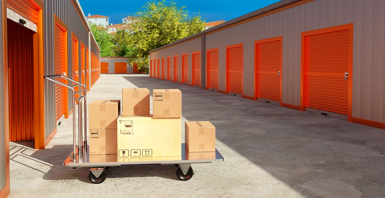 Une femme mesure l'intérieur d'un box de stockage vide avec un mètre ruban.